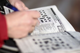 Woman Completing Crossword Puzzle In Newspaper IMG 3077